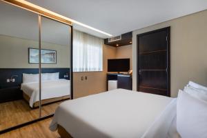 um quarto de hotel com uma cama e uma televisão em Tryp by Wyndham Belo Horizonte Savassi em Belo Horizonte