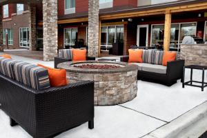 een patio met 2 stoelen en een vuurplaats bij TownePlace Suites by Marriott Louisville Airport in Louisville
