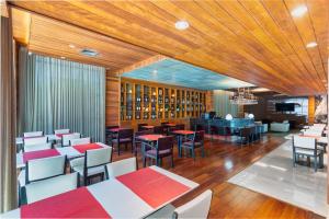 restauracja z drewnianymi sufitami, stołami i krzesłami w obiekcie Tryp by Wyndham Belo Horizonte Savassi w mieście Belo Horizonte