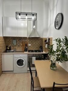 a kitchen with a washing machine and a table with a clock at ANNA'S APARTMENT in Rome