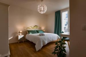 a bedroom with a bed with green pillows and a chandelier at B&B Quattro Stagioni Charme and Wellness in Besnate