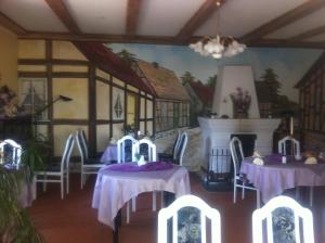 a room with tables and chairs and a fireplace at Natur& Waldhotel Johannesruh in Wesenberg