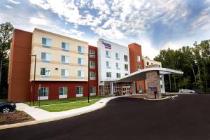 een hotelgebouw met een parkeerplaats ervoor bij Fairfield Inn & Suites by Marriott Richmond Midlothian in Richmond