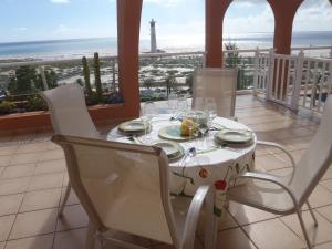 モロ・デル・ハブレにあるTerrazas de Jandíaの灯台のあるバルコニーに白いテーブルクロスがかけられたテーブル