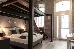 Dormitorio tipo loft con cama elevada y escalera en MADU-Living Vienna - Egon en Viena