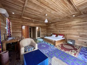 a bedroom with a bed in a wooden cabin at Hotel Restaurant Chez Theo in Bopa