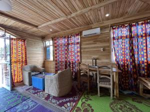 a room with a table and chairs and curtains at Hotel Restaurant Chez Theo in Bopa