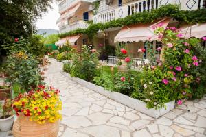 a garden of flowers in front of a building at Borsalino Studios in Nydri