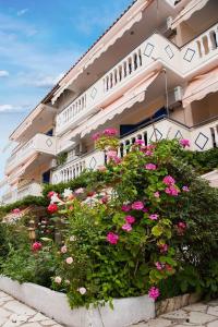 a large building with pink flowers in front of it at Borsalino Studios in Nydri