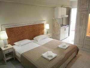 a bedroom with a large bed with two towels on it at Borsalino Studios in Nydri +13 photos