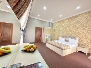 sypialnia z łóżkiem i owocami na stole w obiekcie Istanbul Gold Hotel w mieście Baku