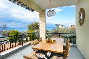 una sala da pranzo con tavolo e sedie sul balcone di Villa Le Tresor a Skala Kallirachis