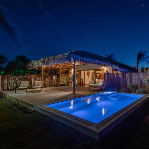 a swimming pool at night with a pavilion at Jaguaríndia Village in Fortim