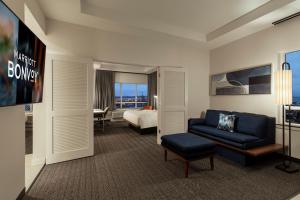 a hotel room with a couch and a bed at Courtyard by Marriott Houston Kemah in Kemah