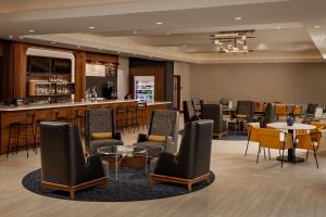 a lobby of a hotel with chairs and a bar at Courtyard by Marriott Houston Kemah in Kemah