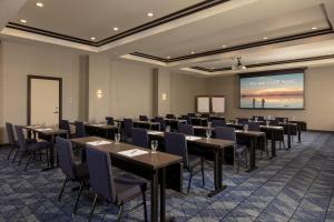 a conference room with tables and chairs and a projection screen at Courtyard by Marriott Houston Kemah in Kemah