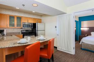 a kitchen with a table and chairs in a room at Residence Inn Bakersfield in Bakersfield