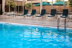 einen Pool mit Stühlen, Tischen und Sonnenschirmen in der Unterkunft Marriott Columbia in Columbia