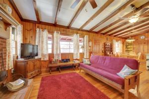 een woonkamer met een paarse bank en een tv bij The Red Loft Candler Cottage 18 Mi to Asheville! in Candler