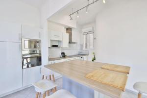 uma cozinha com paredes brancas e um balcão de madeira em Appartement Key West à Saint Raphaël em Saint-Raphaël