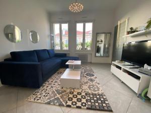 uma sala de estar com um sofá azul e uma televisão em Appartement Key West à Saint Raphaël em Saint-Raphaël
