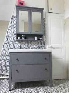 eine Kommode mit einem Spiegel darüber im Bad in der Unterkunft Maison bourgeoise in Fillé