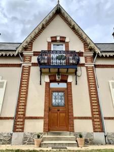 ein Gebäude mit einer Holztür und einem Balkon in der Unterkunft Maison bourgeoise in Fillé