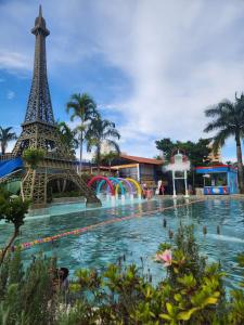 a pool with the eiffel tower in the background at WM Araras Apart Caldas Novas in Caldas Novas