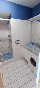 ein Bad mit einer Waschmaschine und einer Dusche in der Unterkunft Ancora- Appartement vue mer et place de parking in Les Sables-dʼOlonne