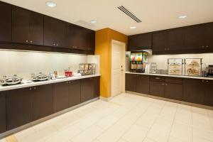 a large kitchen with brown cabinets and a refrigerator at Residence Inn by Marriott Bloomington in Bloomington