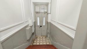a hallway with a white door and a window at Glória 10 in Lisbon