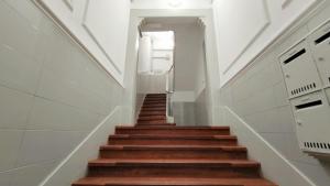 a staircase in a house with white walls and wooden floors at Glória 10 in Lisbon