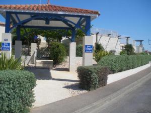 a walkway with a gazebo and some bushes at Maisonnette du Sémaphore - Jardin, piscine & parking à La Chaume in Les Sables-d'Olonne