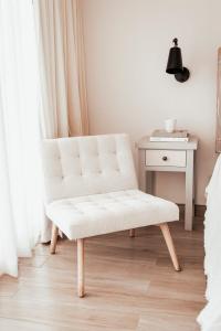 Una silla blanca en un dormitorio con mesa en Villas Ensueño en San Antonio de las Minas