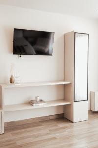 a white living room with a tv on a wall at Villas Ensueño in San Antonio de las Minas