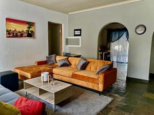 a living room with a couch and a table at Horizon Green Guest House in Randfontein