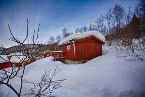 a small redshed with snow on top of it at Kvetos fjellgårdsutsikt in Beitostøl