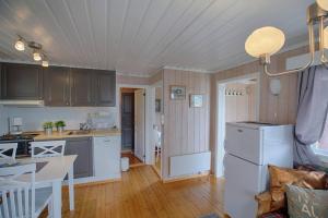 a kitchen and living room with a white refrigerator at Kvetos fjellgårdsutsikt in Beitostøl +2 photos