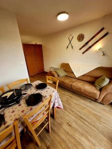een woonkamer met een tafel en een bank bij appartement t2 cosy 4 à 6personnes la gentiane in Superdevoluy