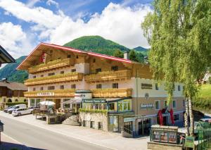 een groot hotel met een berg op de achtergrond bij Apparthotel Panorama in Flachau