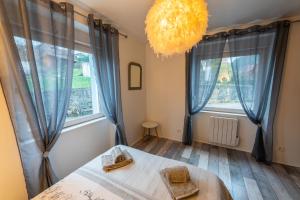 a bedroom with a bed and a large window at Gîte l'Améthyste 3 appartements in Gérardmer