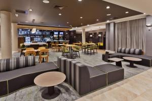 a hotel lobby with tables and chairs and a restaurant at Courtyard by Marriott Greenville Mauldin in Greenville