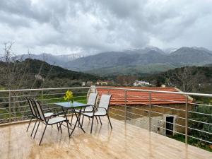 a table and chairs on a balcony with mountains at Fast Wi-Fi 50mbps,Pet Friedly,Free parking in Nerokoúros