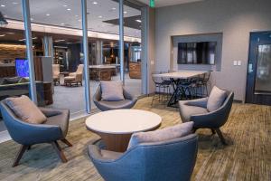 eine Lobby mit Stühlen, einem Tisch und einem Tisch in der Unterkunft Courtyard by Marriott Greenville Mauldin in Greenville