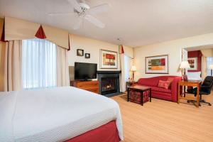 Residence Inn Kalamazoo East في كالامازو: غرفة فندقية بها سرير وموقد