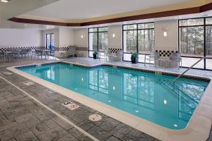 a pool in a hotel with tables and chairs at SpringHill Suites Manchester-Boston Regional Airport in Manchester