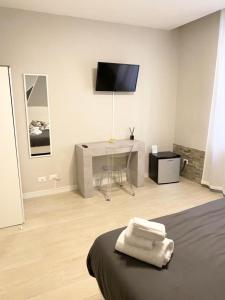 una camera con letto e scrivania con TV di B&B La Stella a Pisa