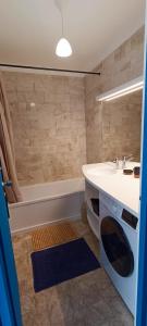 La salle de bains est pourvue d'un lavabo et d'une baignoire. dans l'établissement MIREILLE - Appartement 4 etoiles vue mer - 2 a 4 pers, à Les Sables-dʼOlonne