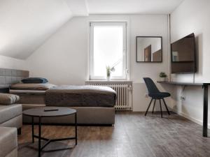 ein Wohnzimmer mit einem Bett und einem Sofa in der Unterkunft LIGHTPLACE • Größere Gruppen • 4 Einzelzimmer • Boxspring • Smart TV • Biergarten • Restaurant in Braunschweig