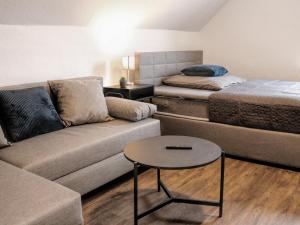 a living room with a couch and a bed at LIGHTPLACE • Größere Gruppen • 4 Einzelzimmer • Boxspring • Smart TV • Biergarten • Restaurant in Braunschweig